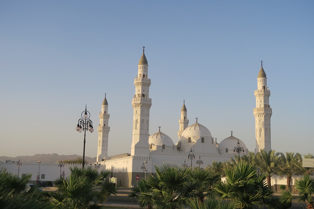 a large white building surrounded by palm trees, by Kamāl ud-Dīn Behzād, pixabay, dau-al-set, minarets, soft morning light, twins, afar