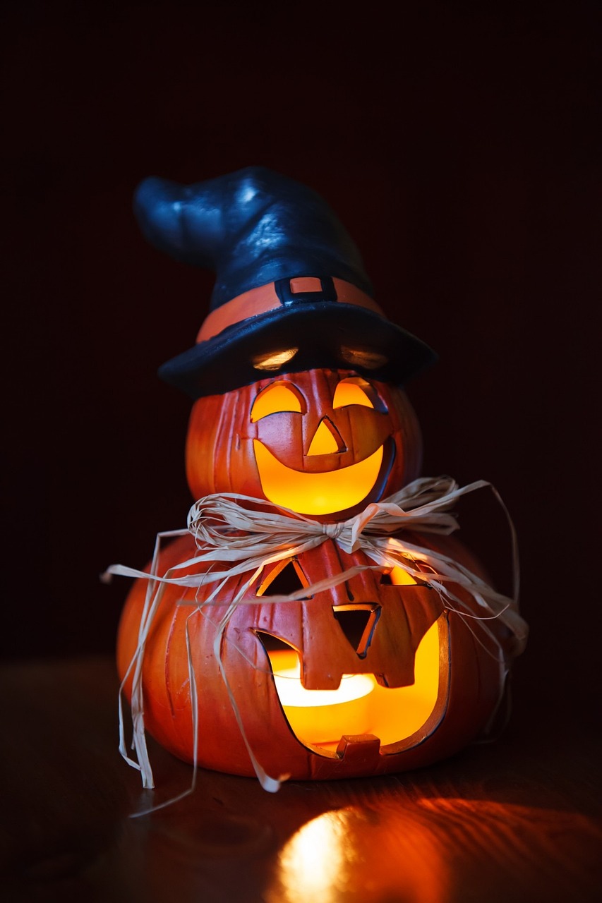 a halloween pumpkin sitting on top of a table, a portrait, by Stefan Gierowski, pexels, archwizzard in a hat, made of glowing wax and ceramic, closeup of an adorable, close together