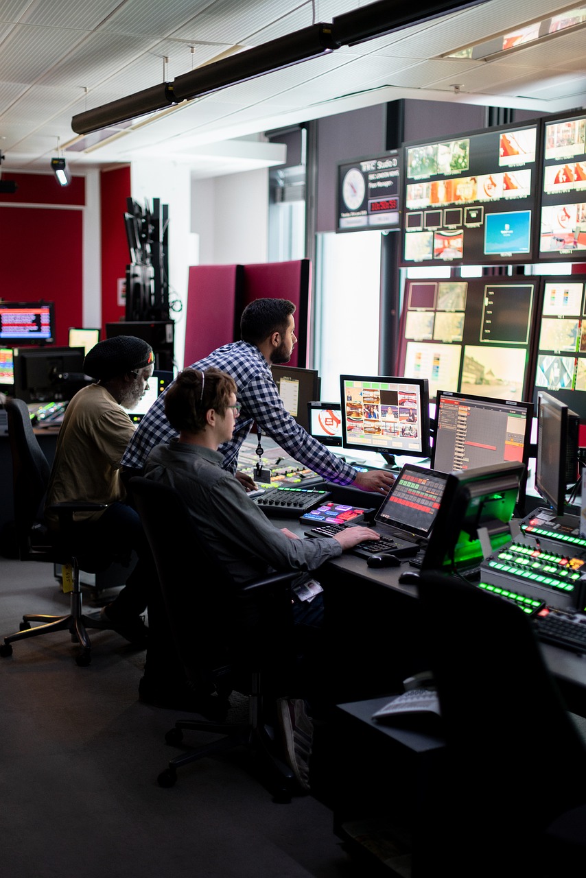 a group of people sitting at computers in a room, tv production, high res photo, london, red weapon 8 k s 3 5