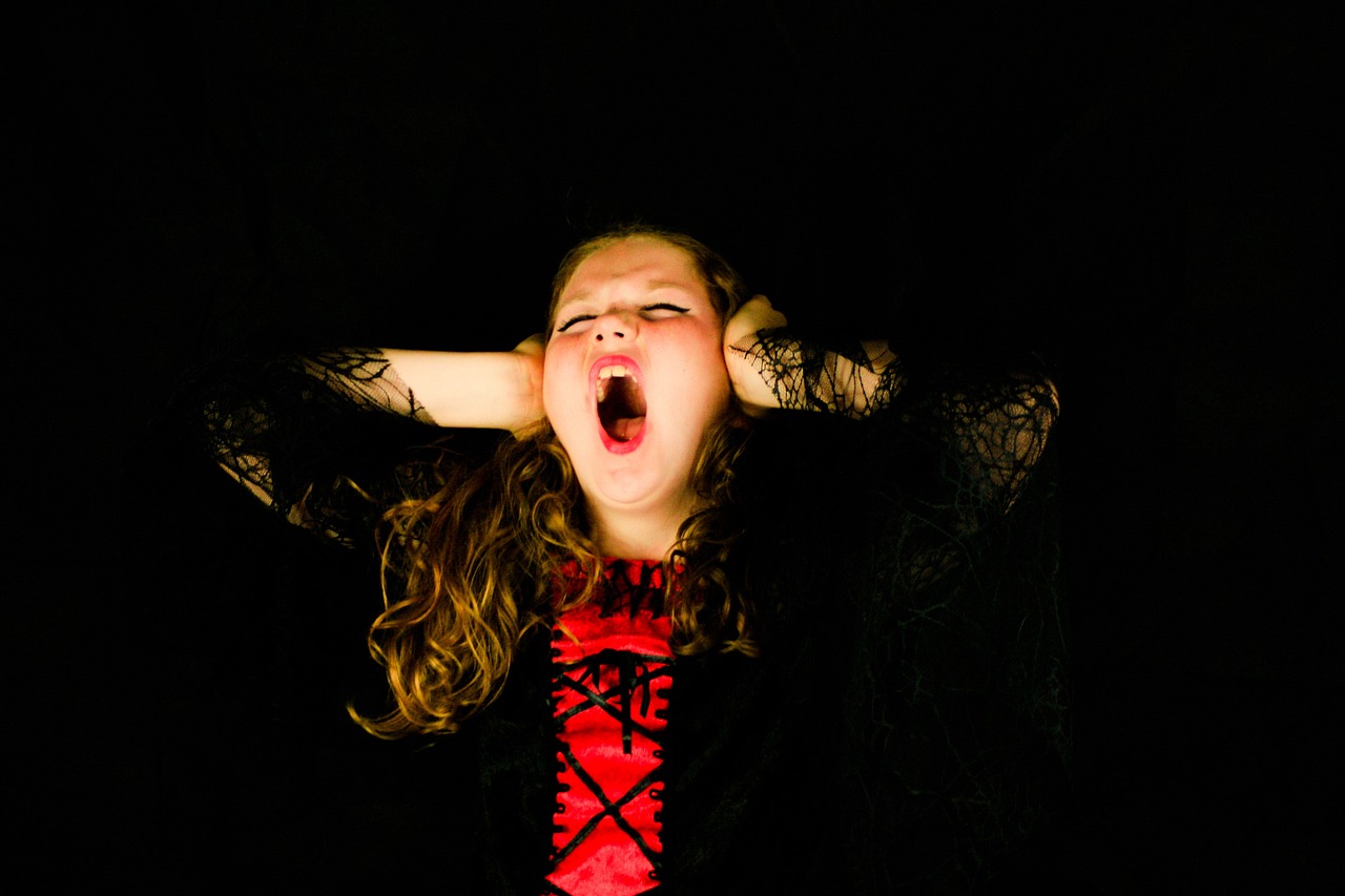 a girl with her mouth open in the dark, a picture, headbanging, as a vampire, kid, marketing photo