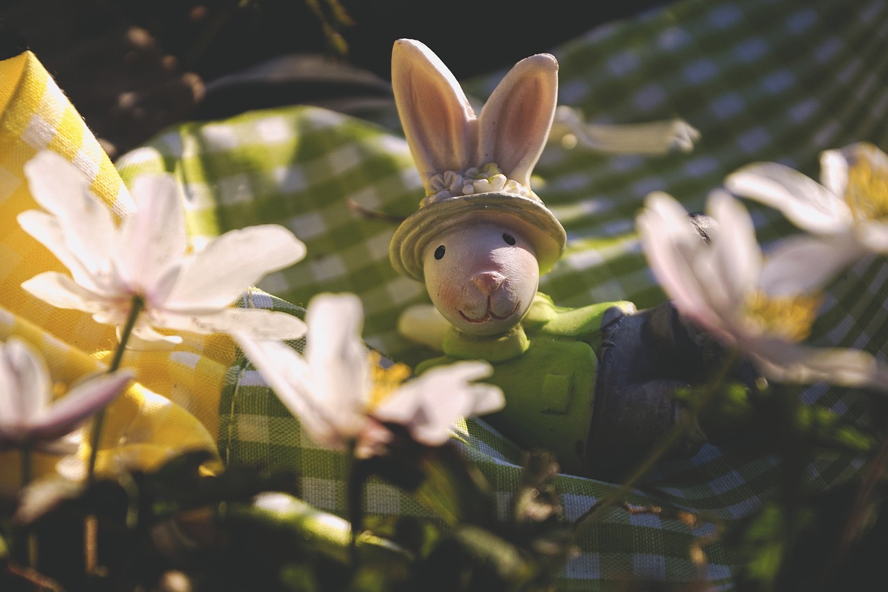 a close up of a stuffed animal wearing a hat, a picture, by Pamela Ascherson, pixabay contest winner, happening, lying on a bed of daisies, rabbt_character, ceramic, claymation character