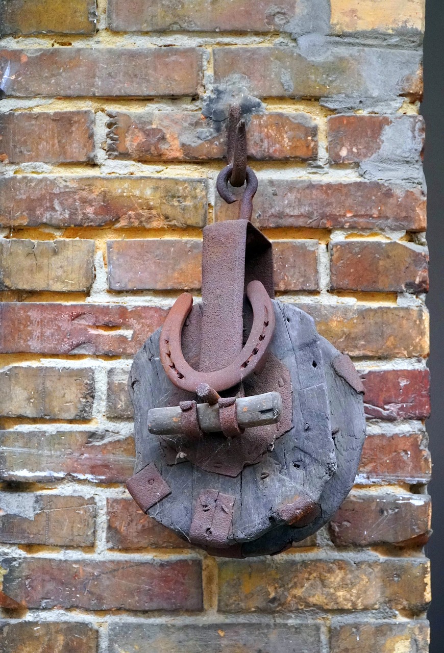 a rusted metal hook attached to a brick wall, inspired by Hans Bol, flickr, assemblage, helm, made of intricate metal and wood, moored, slave collar