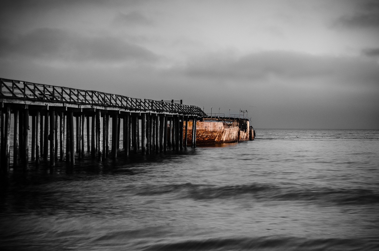 a black and white photo of a pier, a black and white photo, saturated colorized, golden hour in pismo california, sunken ship, taken with sony a7r camera