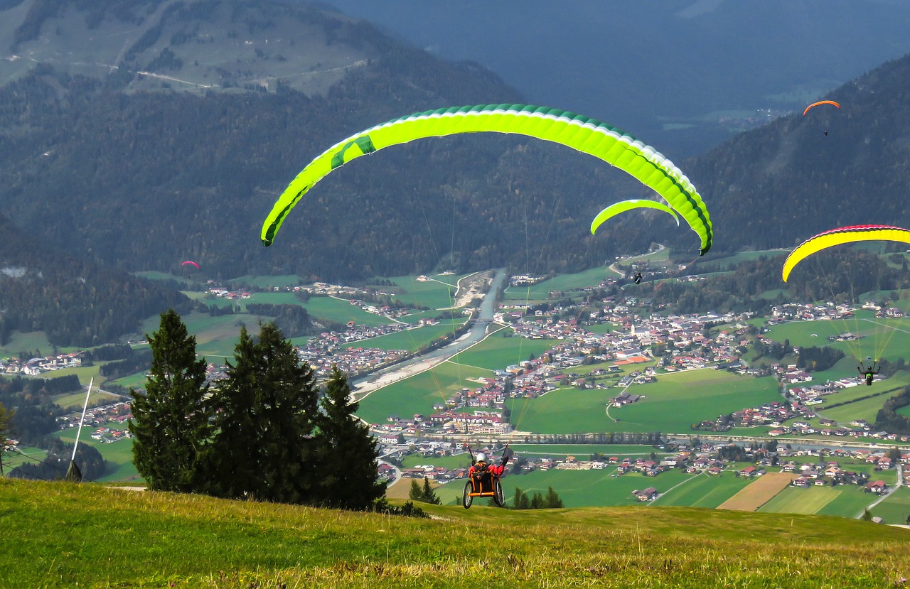 a group of people flying kites over a lush green hillside, a picture, by Erwin Bowien, flickr, at takeoff, alpine, ramps, green valley below