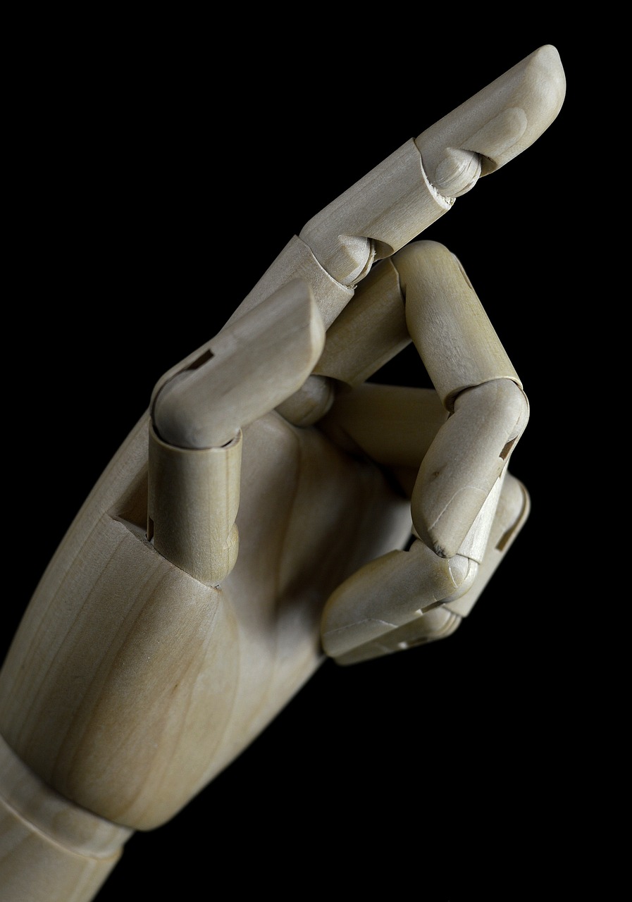 a wooden hand making a peace sign with it's fingers, a macro photograph, visual art, ball jointed doll, on a black background, robotic limb, half body photo