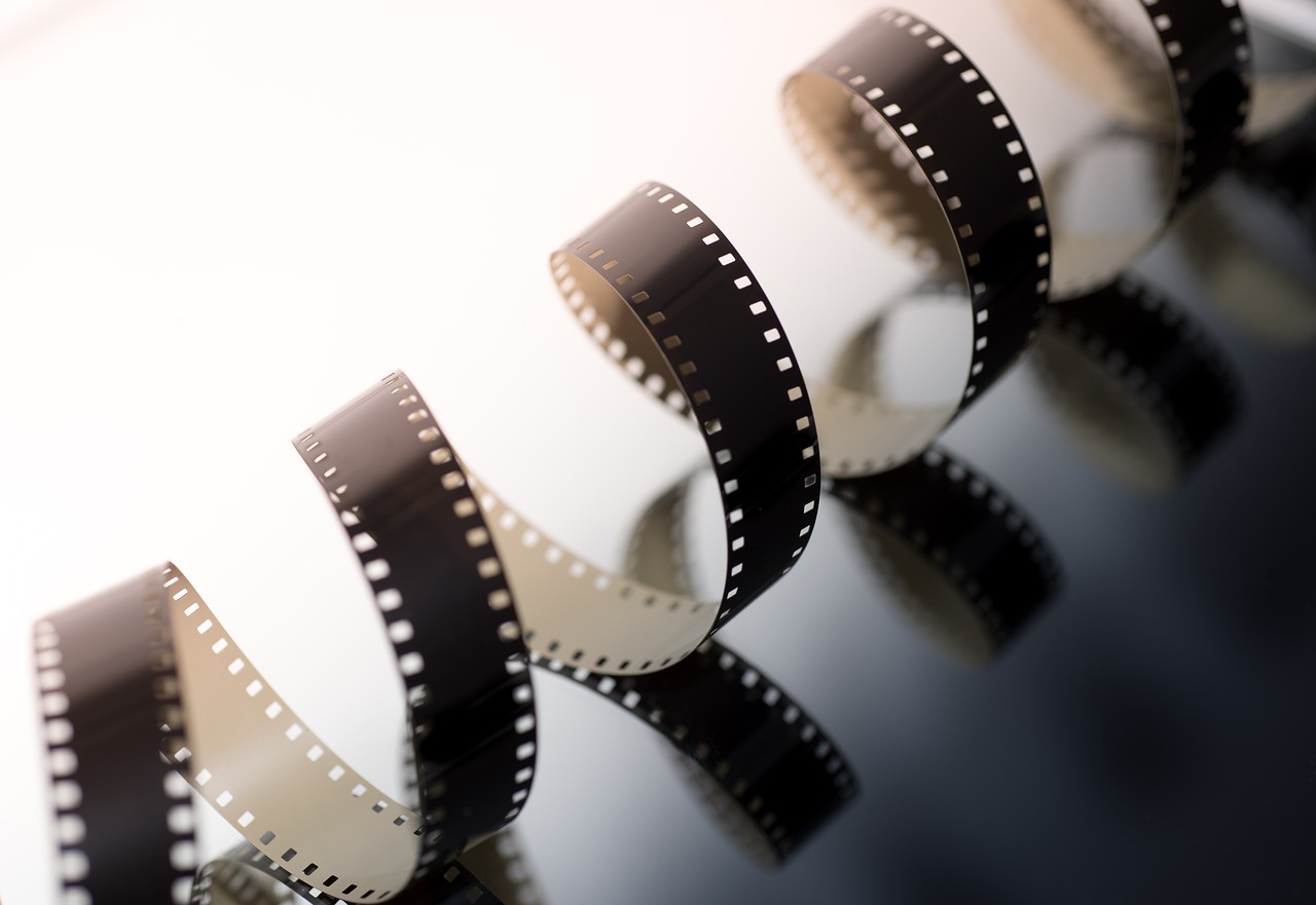 a roll of film sitting on top of a table, a picture, inspired by roger deakins, shutterstock, bright cinematic backlit, vertical movie frame, film strip reel showing 9 frames, 1920s film