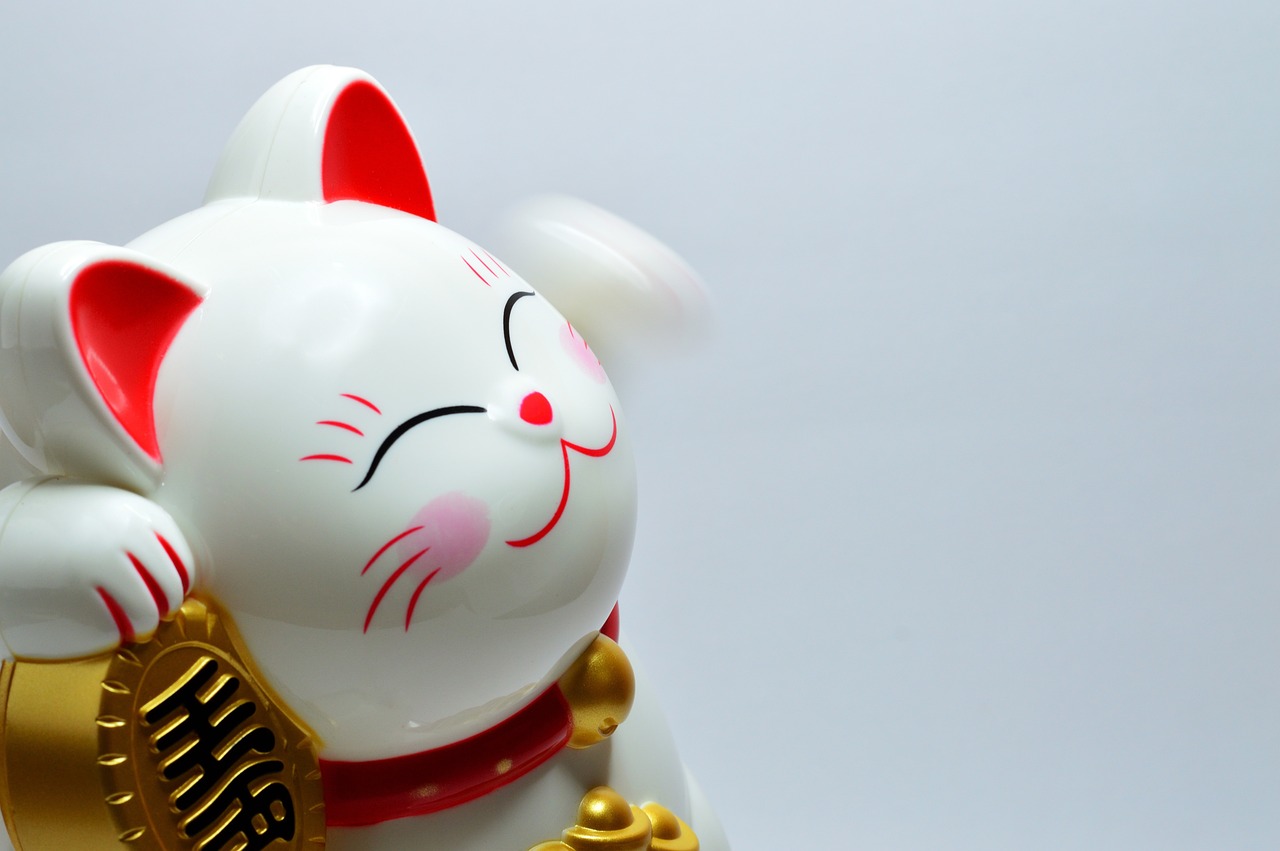 a close up of a figurine of a cat, trending on pixabay, sōsaku hanga, whirling, white background!!!!!!!!!!, shining and happy atmosphere, god of wealth