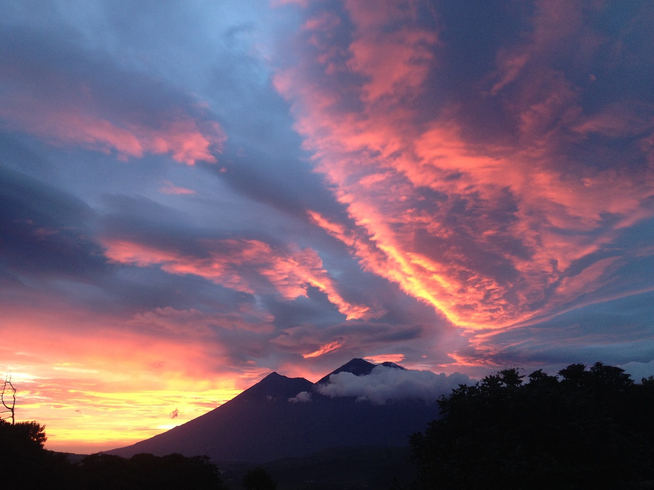 a picture of a sunset with a mountain in the background, happening, karla ortiz, red clouds, lerapi, highly colorful