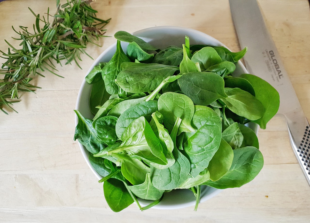 a bowl of spinach and a knife on a table, a picture, 🌻🎹🎼, herbs, very very precise, 🪔 🎨;🌞🌄