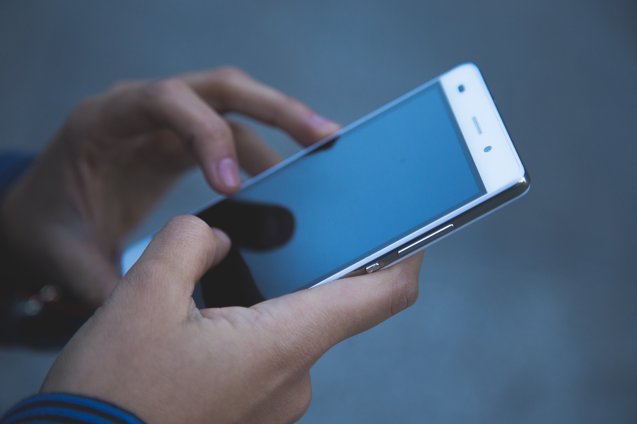 a close up of a person holding a cell phone, happening, smooth edges, android format, wikimedia commons, istock