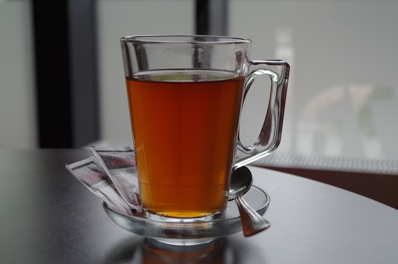 a glass of tea sitting on top of a table, by Dietmar Damerau, flickr, terminal, shogakukan, side - view, caramel
