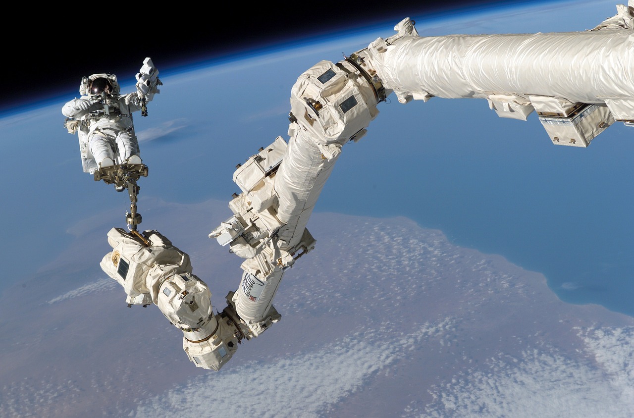 a couple of astronauts standing on top of a space station, a picture, inspired by Jan Rustem, pexels, nasa canadarm, using a exoskeleton, big train in space, brown exoskeleton