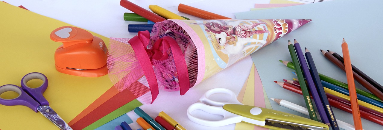 a bunch of craft supplies sitting on top of a table, a pastel, by January Suchodolski, pixabay, big ribbon, cone shaped, circus, child's drawing
