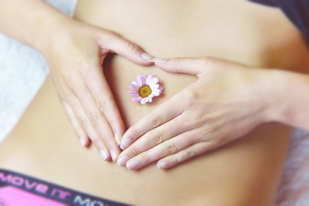 a close up of a person making a heart shape with their hands, by Ivana Kobilca, romanticism, belly button showing, pink flower, holistic medicine advertisement, lobotomy of a beautiful woman
