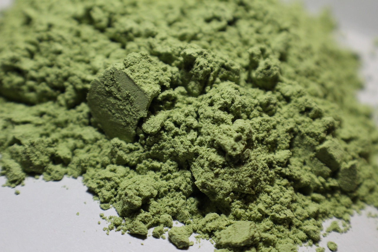 a pile of green powder sitting on top of a table, inspired by Masamitsu Ōta, flickr, hurufiyya, high angle close up shot, pale green background, ultra-realistic, palladium