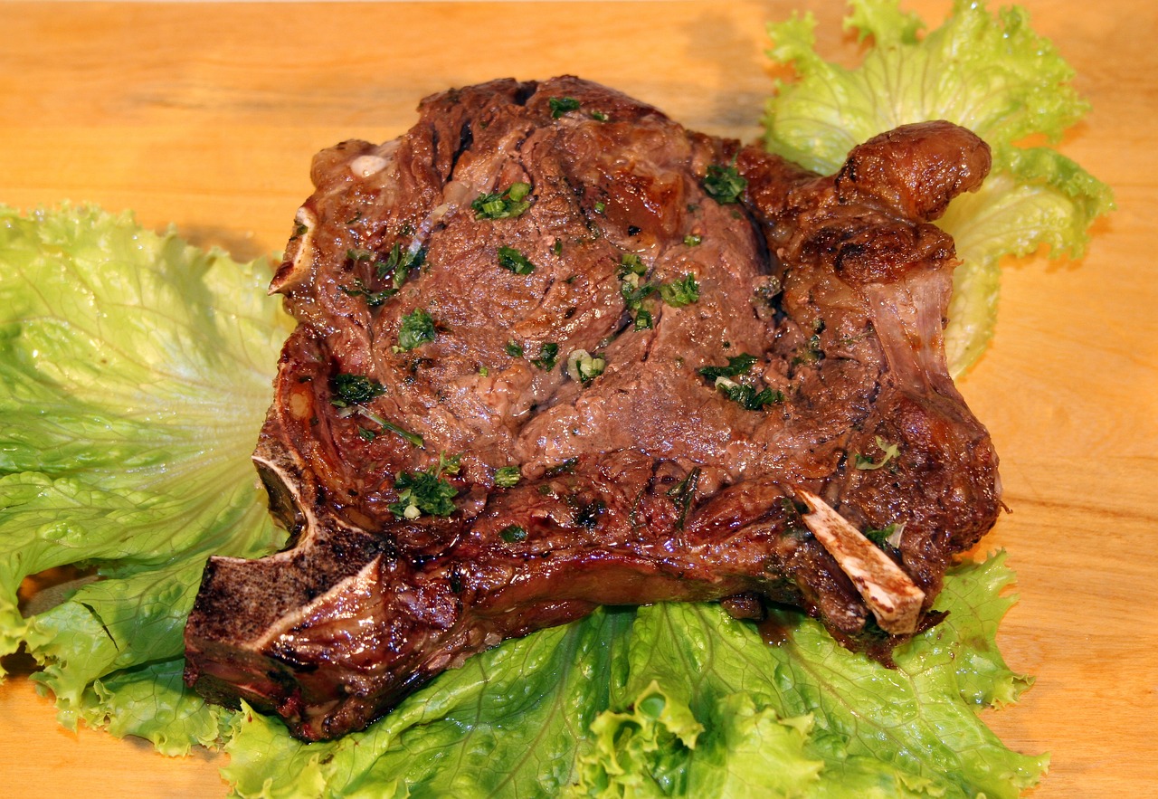 a large piece of meat sitting on top of lettuce, mutton chops, basil gogos, photo - shot, calf