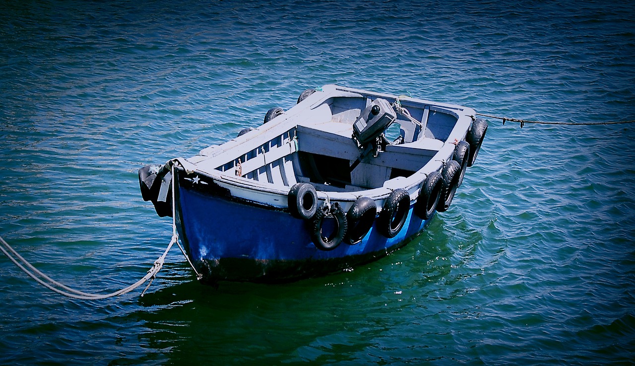 a blue and white boat sitting on top of a body of water, a photo, flickr, dark dingy, vivid colors!, deep colours. ”, strong blue rimlit