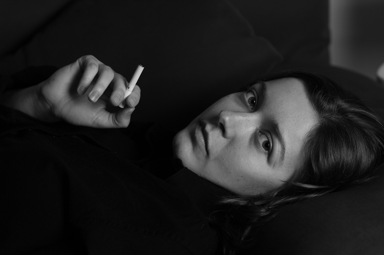 a woman laying on a couch with a cigarette in her hand, a portrait, inspired by irakli nadar, unsplash, fine art, beautiful taissa farmiga, hedi slimane, 4 k asymmetrical portrait, portrait of florence pugh