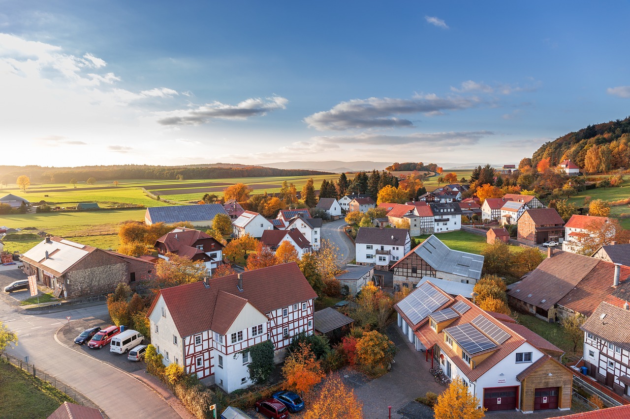 a bird's eye view of a small town, by Karl Hagedorn, shutterstock, at sunset in autumn, real estate photography, flat perspective, small houses