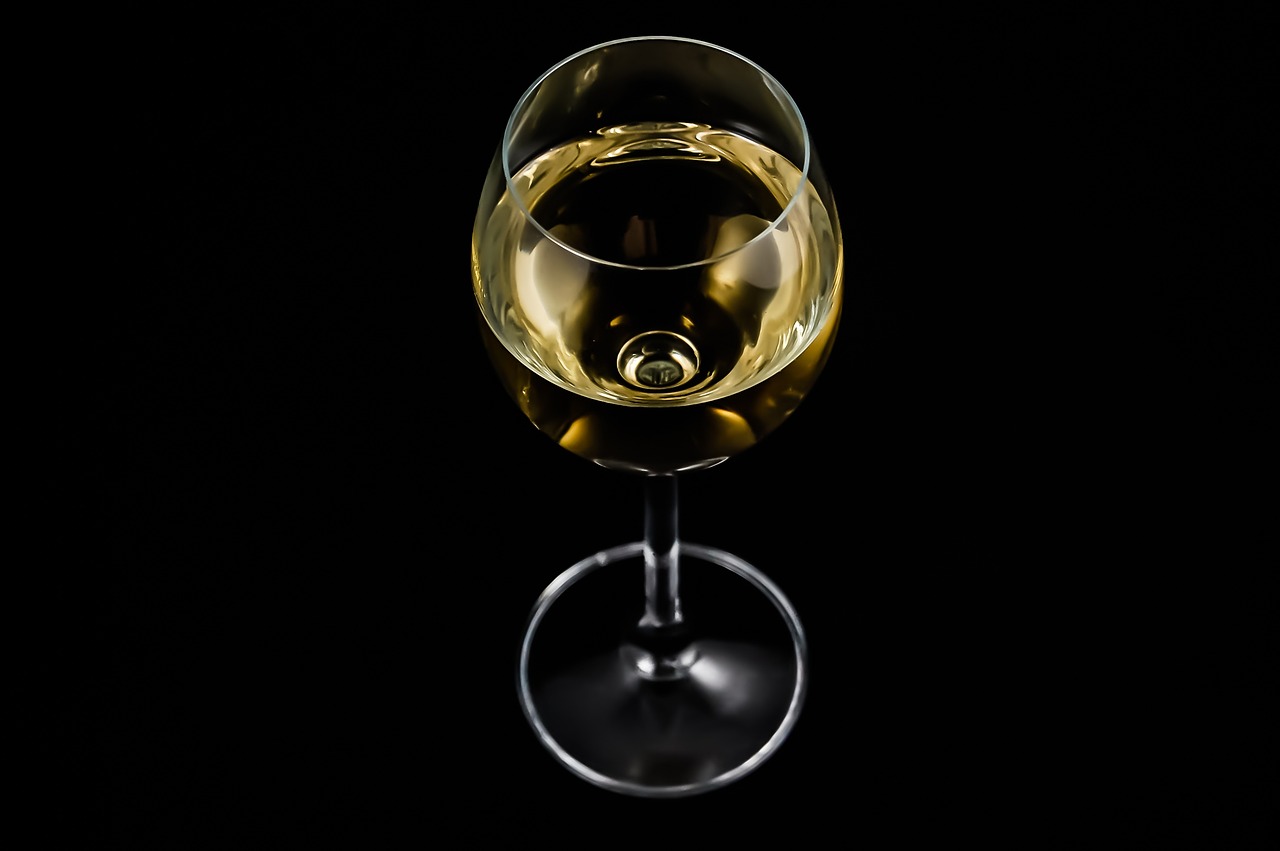 a glass of white wine on a black background, by Jan Rustem, bottom - view, miniature product photo
