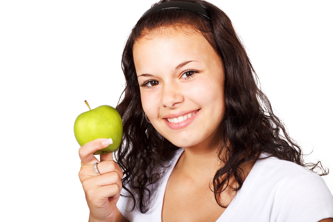 a woman holding a green apple in front of her face, by John Luke, pixabay, smiling girl, with a white background, square, 19-year-old girl