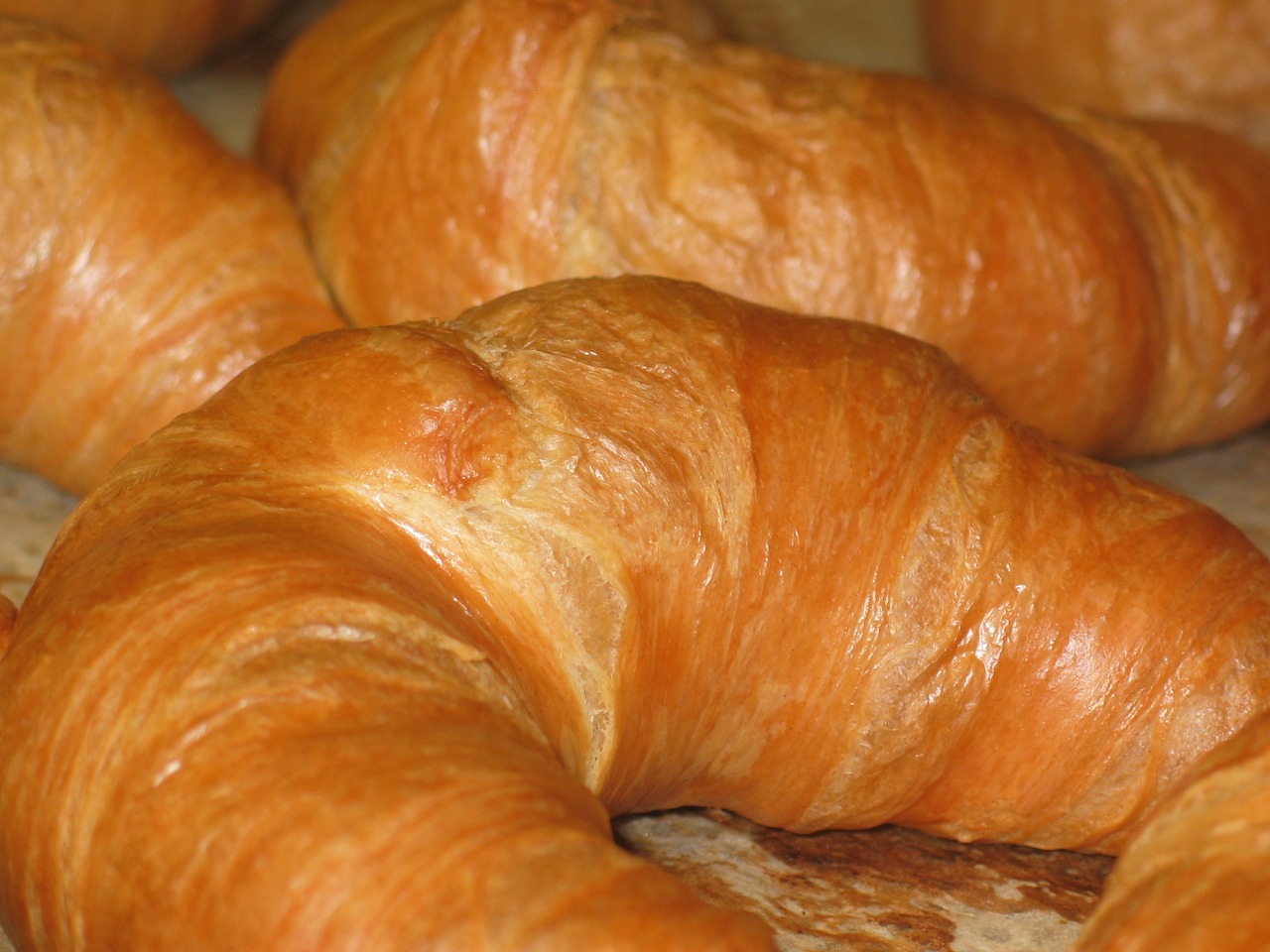 a bunch of croissants sitting on top of a table, hurufiyya, closeup - view, award-winning crisp details”, amber, grain”