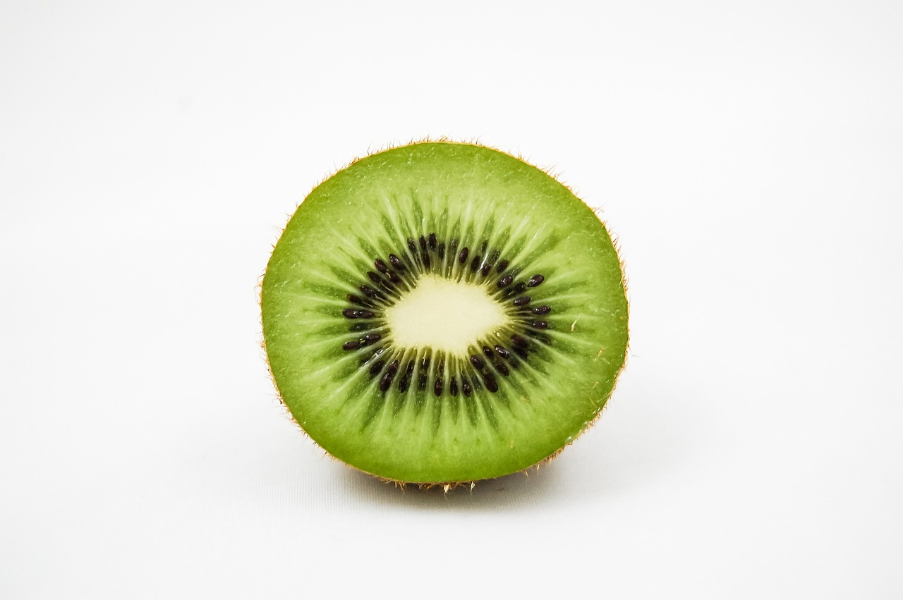 a kiwi cut in half on a white surface, by Tadashi Nakayama, pexels, hurufiyya, green eyes. 2 4 mm, maori, 2000s photo, 1/320