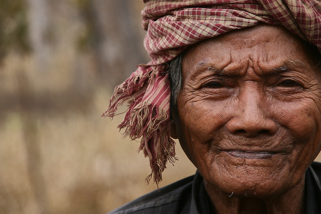 a close up of a person wearing a headscarf, a picture, by Jesper Knudsen, pexels contest winner, sumatraism, angkor, older male, smiling woman, ancient tribe
