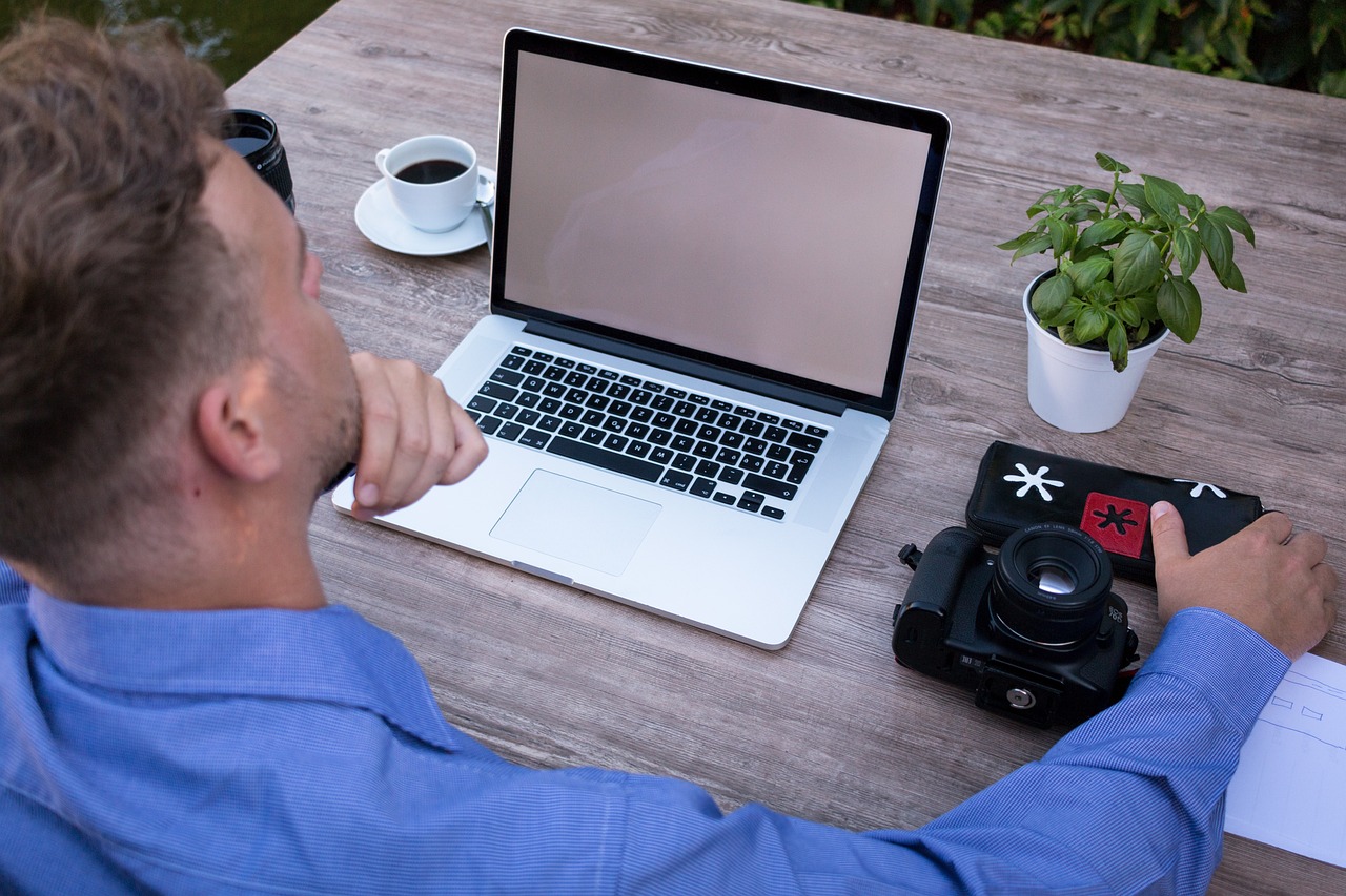a man sitting at a table with a laptop computer, pexels, realism, outside, very accurate photo, professional render, dlsr photo