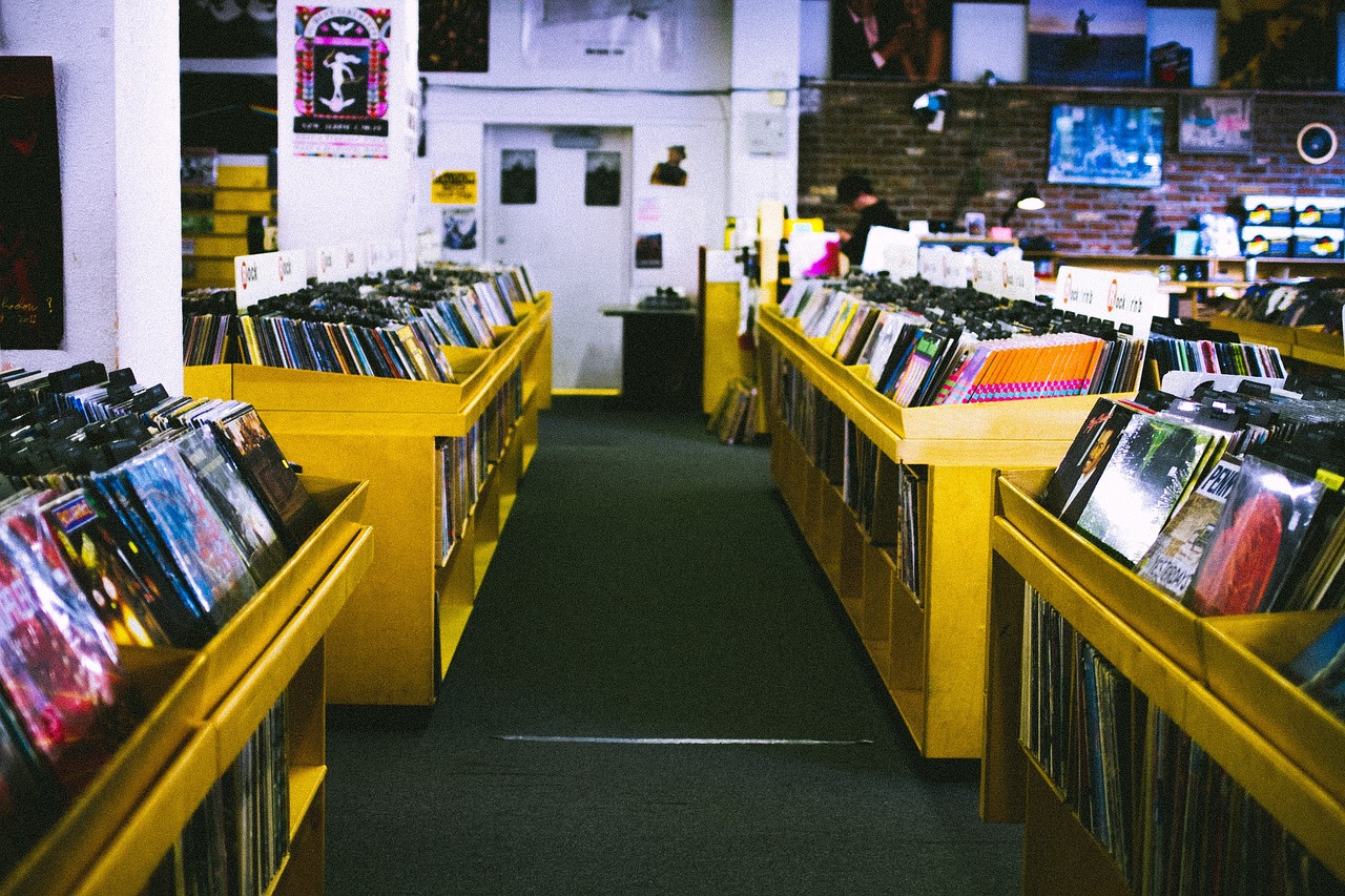 a store filled with lots of cds and cds, unsplash, yellow carpeted, los angeles, tony taka, nostalgic atmosphere