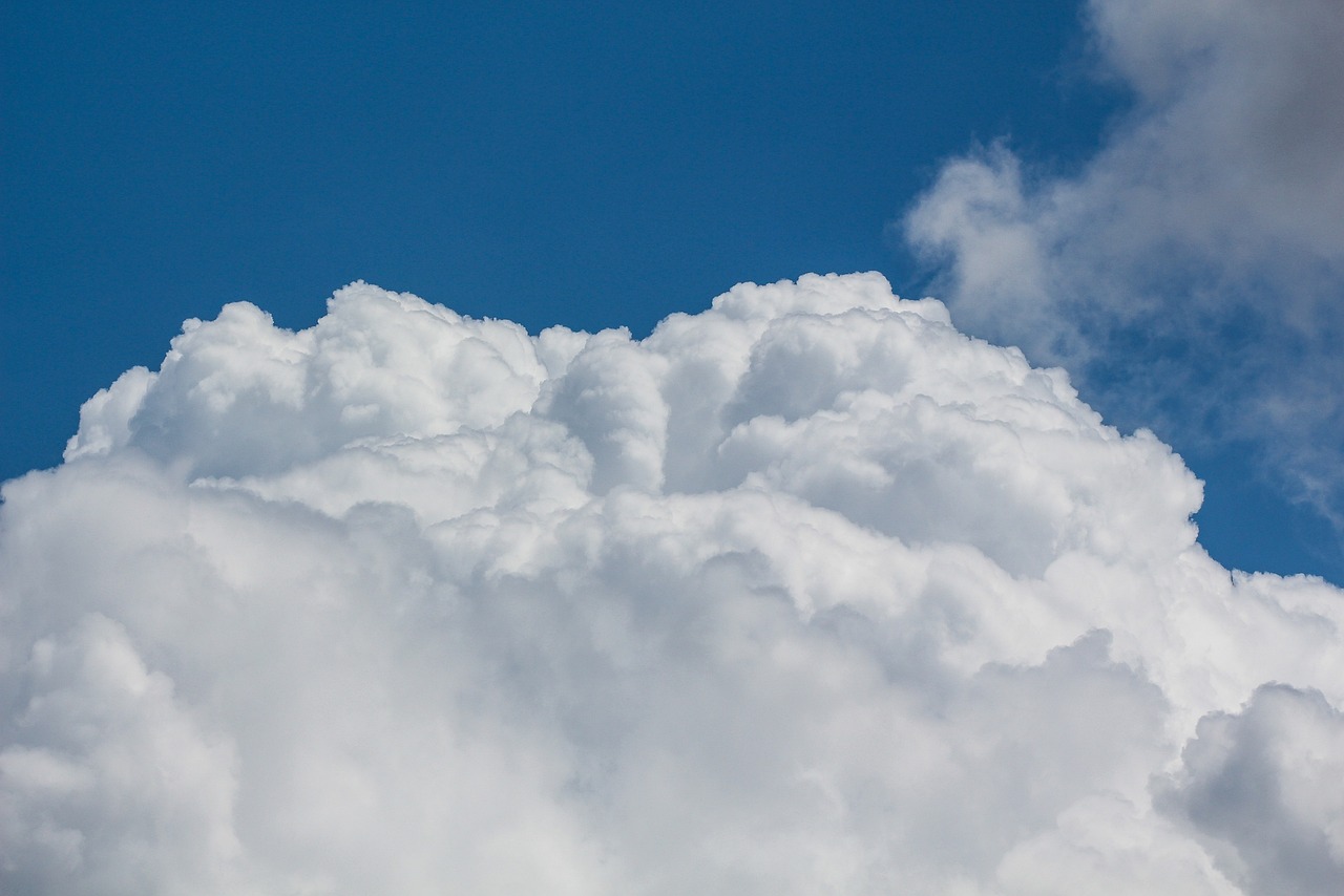 a plane flying through a cloud filled blue sky, a stock photo, minimalism, clouds of vivid horse-hair wigs, tattoos of cumulus clouds, middle close up composition, thunder clouds modernism