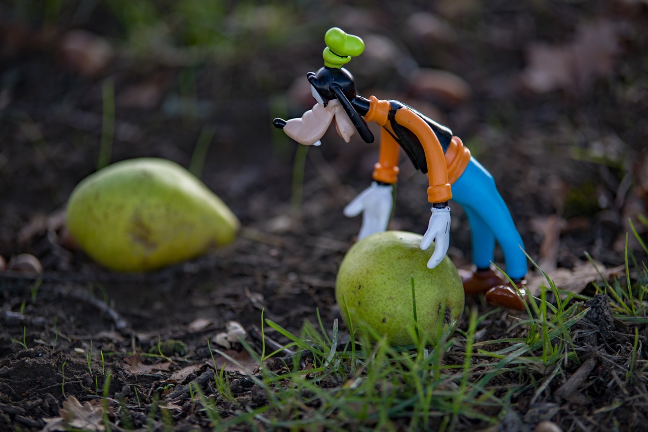 a figurine of a man standing on top of a green apple, a picture, inspired by Tex Avery, shutterstock, figuration libre, crash bandicoot, outdoor photo, shot on nikon z9, his head is a pear