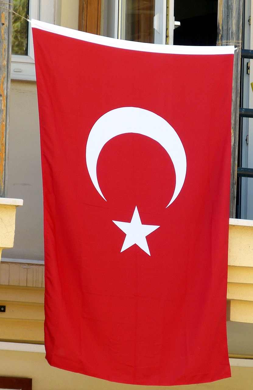 a red and white turkish flag hanging in front of a window, pexels, hurufiyya, header text”, wikimedia, tall, shell