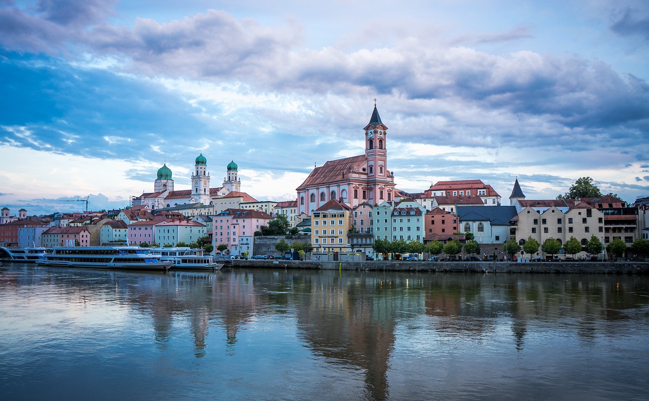a large body of water with a city in the background, a picture, by Jakob Gauermann, shutterstock, art deco, church, austria, pink reflections, tonemapped