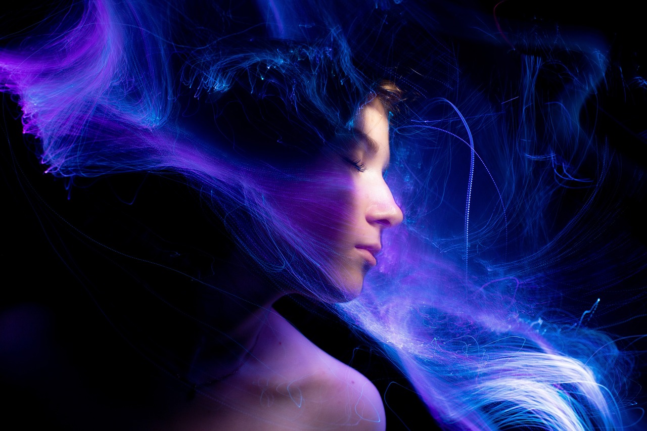 a close up of a person holding a cell phone, digital art, by Eugeniusz Zak, digital art, blue and purple glowing hair, lightpainting motion blur, beautiful young wind spirit, mysterious portrait of a woman