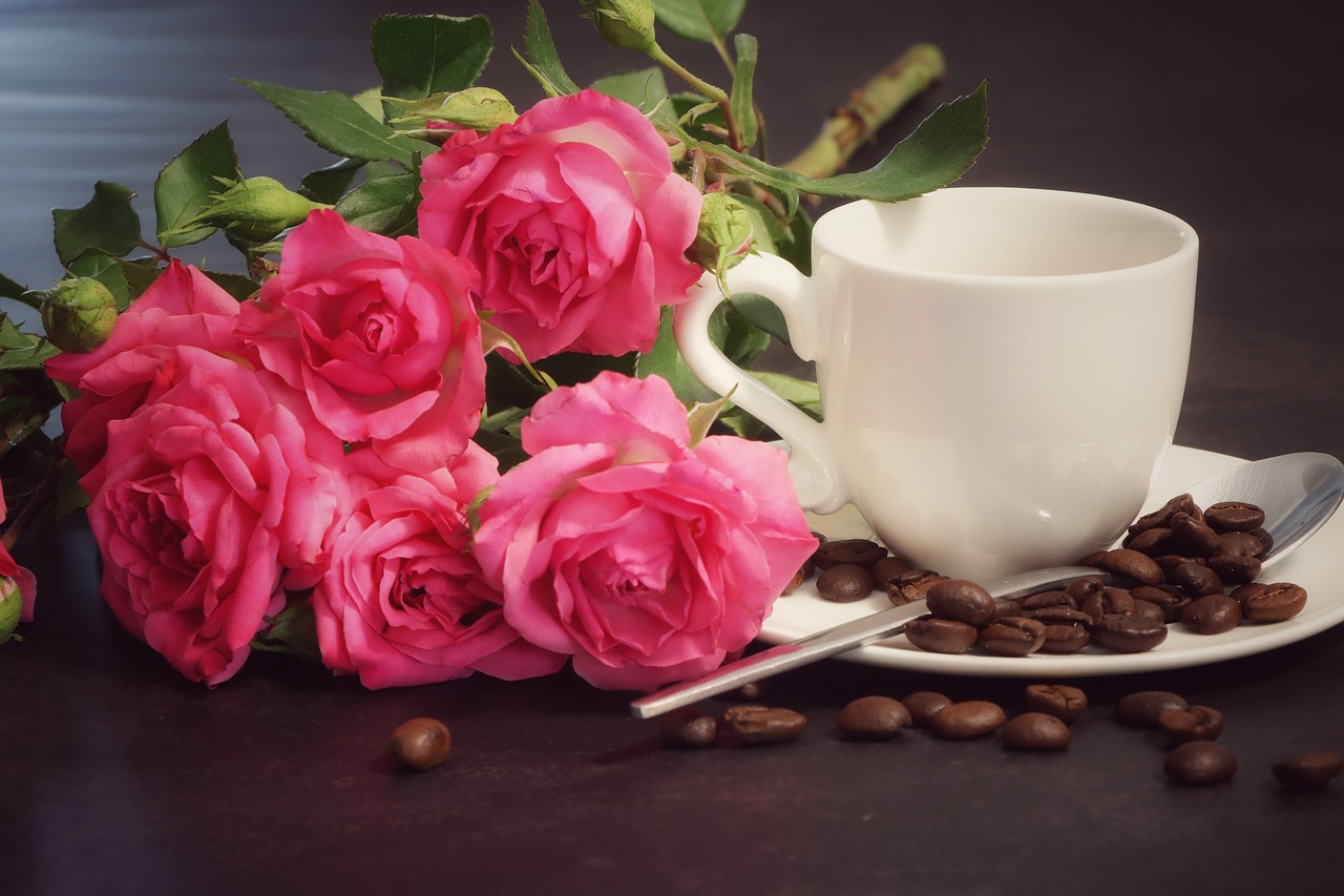 a cup of coffee next to a bunch of pink roses, romanticism, against dark background, advertising photo