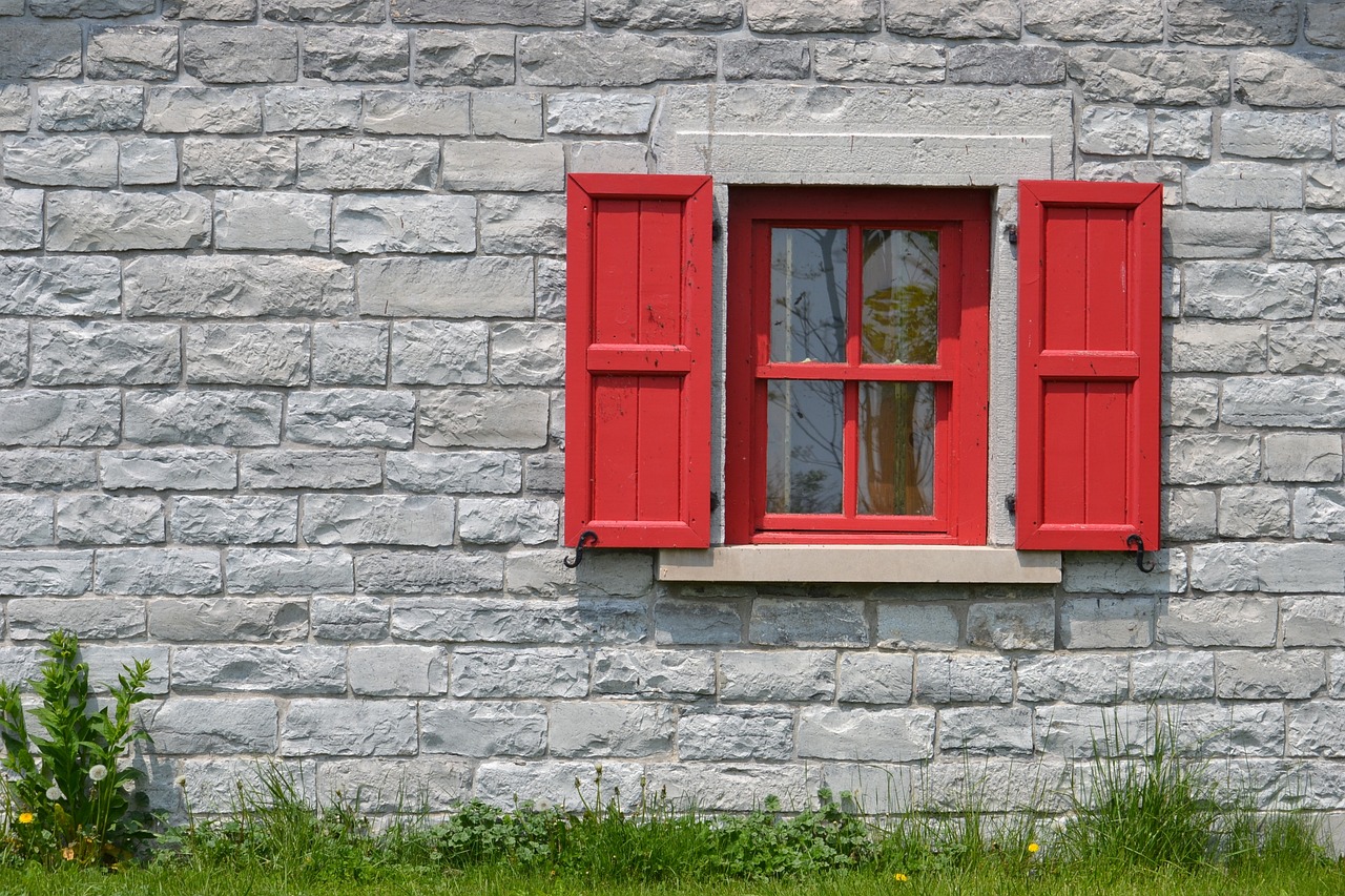 a red window sitting on the side of a stone building, inspired by A. J. Casson, shutterstock, shutters, high definition detail, david myers, yard