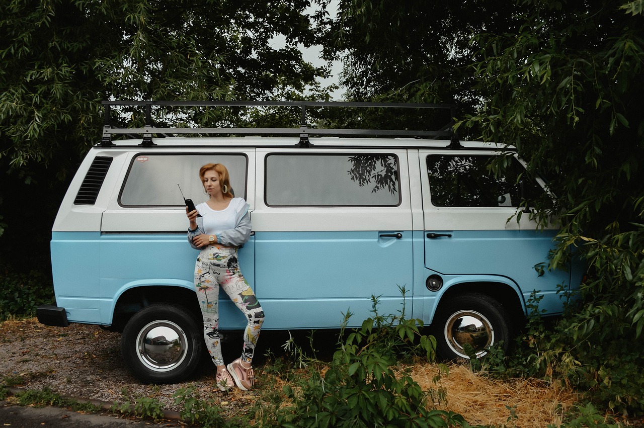 a woman sitting on top of a blue van, a portrait, unsplash, shot on hasselblad, full legs, retro and 1 9 8 0 s style, olga buzova