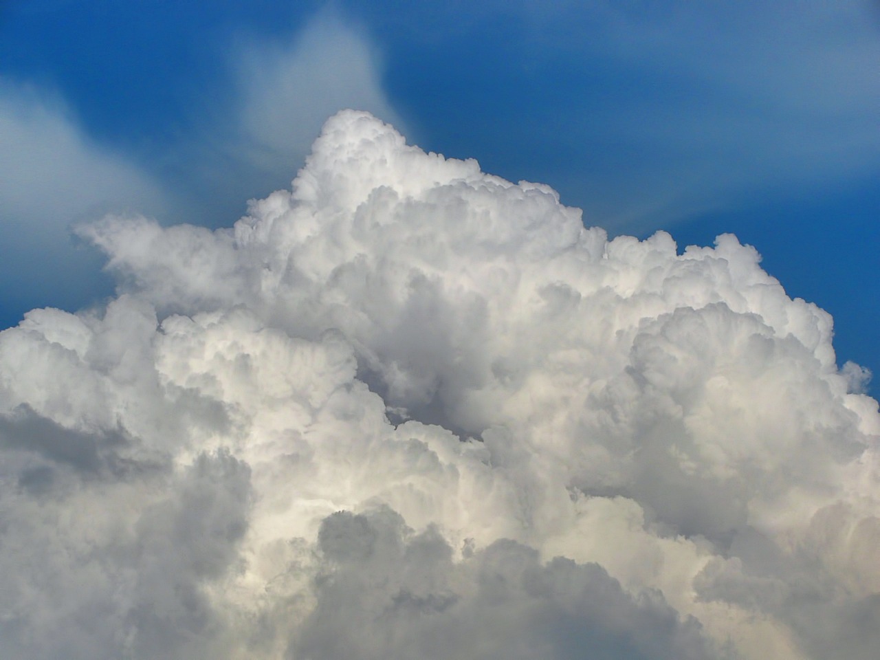 a plane flying through a cloud filled blue sky, a portrait, by Jan Rustem, precisionism, giant cumulonimbus cloud, detailed zoom photo, closeup photo, clouds of vivid horse-hair wigs