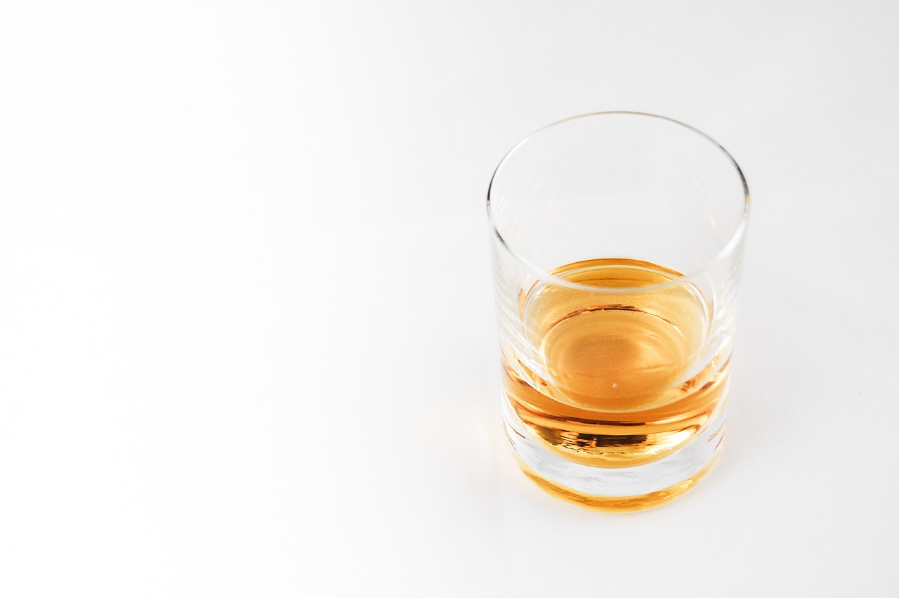 a glass filled with liquid sitting on top of a table, inspired by William Grant Stevenson, minimalism, dof wide, drinking whiskey, high detail product photo