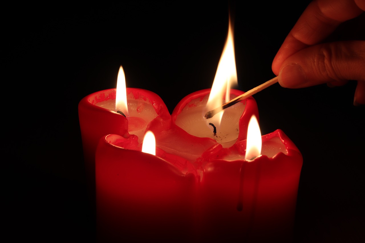 a person lighting a candle with a matchstick, by Eugeniusz Zak, shutterstock, romanticism, trio, glowing red, stock photo, trinity