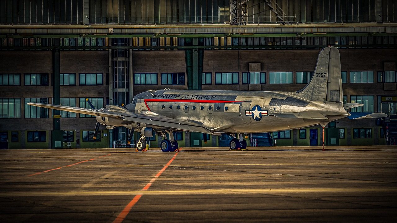 a silver airplane sitting on top of an airport tarmac, a portrait, by Dave Melvin, stars and stripes, warsaw, posing!!, 1/1250s at f/2.8