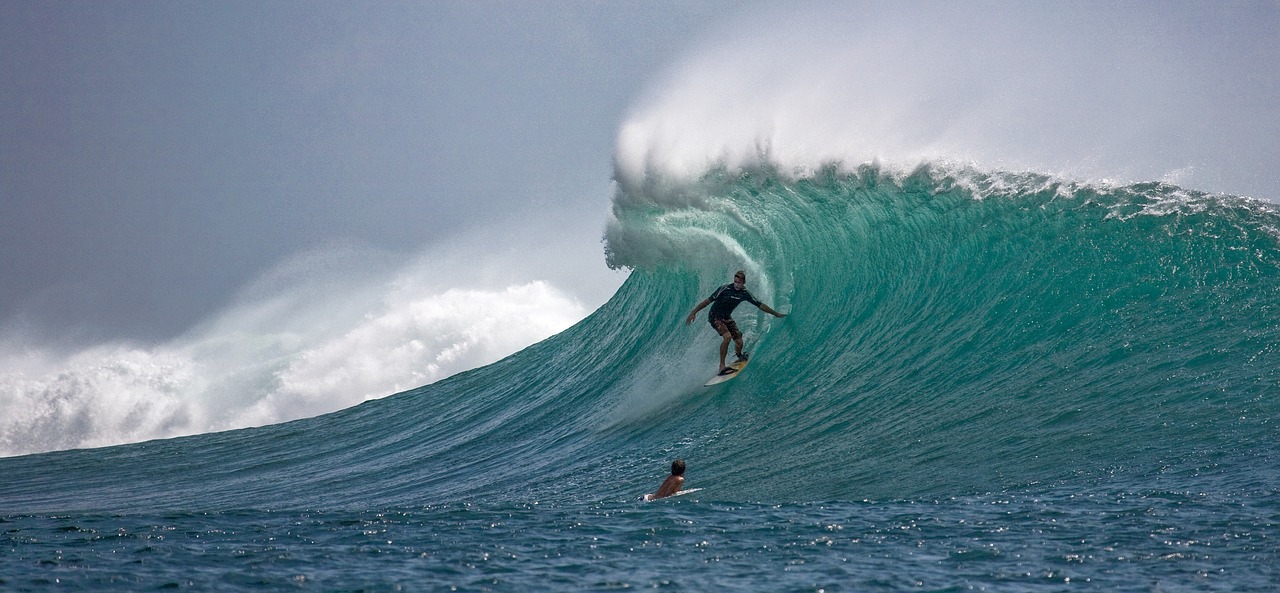 a man riding a wave on top of a surfboard, a photo, by Matt Stewart, flickr, sumatraism, wall of water either side, digging, enormous in size, action photo