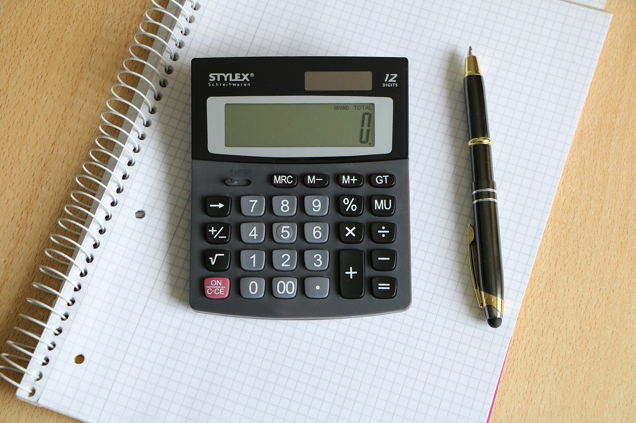 a calculator sitting on top of a notebook next to a pen, a picture, stanley kybric, close-up product photo, 1 2 0 mm, stern