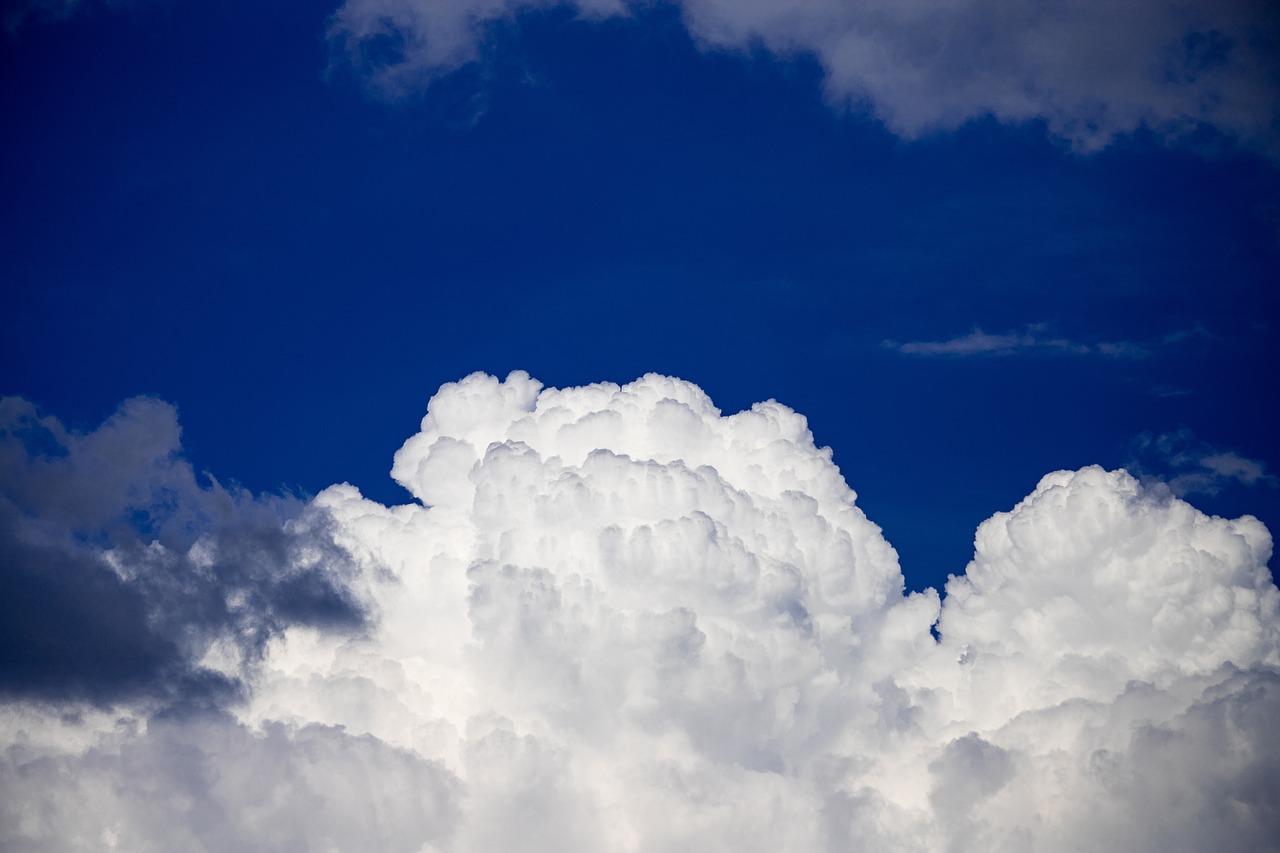 a jetliner flying through a cloudy blue sky, a picture, minimalism, giant cumulonimbus cloud, white cyclops portrait in sky, beautiful cloudy deep blue sky, white foam