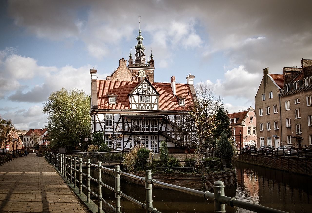 a building that is next to a body of water, by Jacob Kainen, shutterstock, timbered house with bricks, shot on leica sl2, bridge, rococo architecture