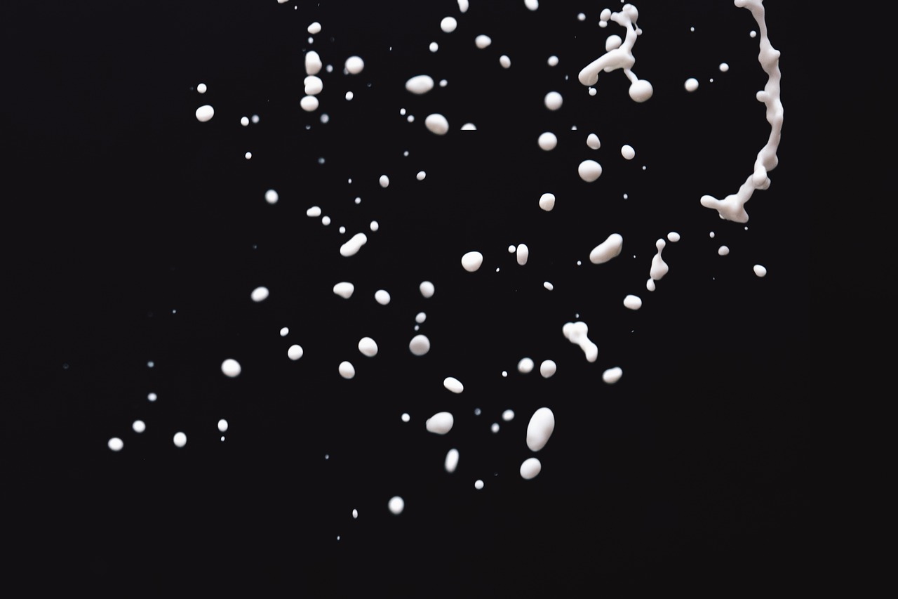 a splash of milk on a black surface, a microscopic photo, minimalism, pills, sugar sprinkled, productphoto