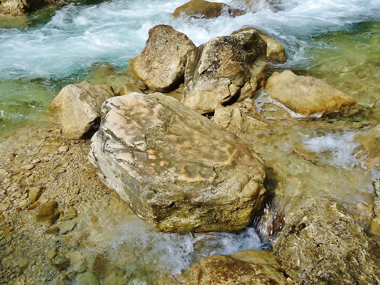 a group of rocks sitting on top of a river, a picture, naturalism, carved stone, uttarakhand, stone slab, discovered photo