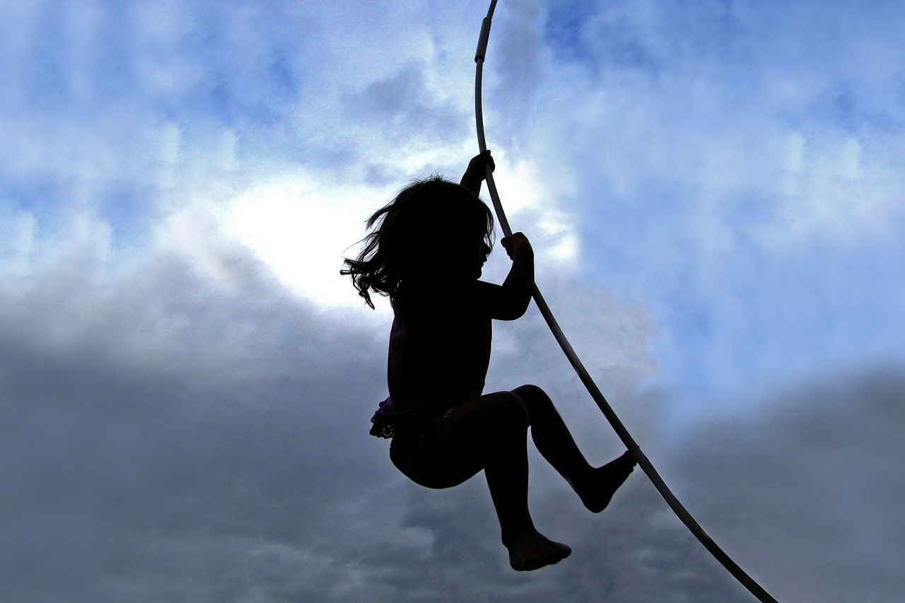 a silhouette of a girl swinging on a rope, flickr, swirling, toddler, high in the sky, curve