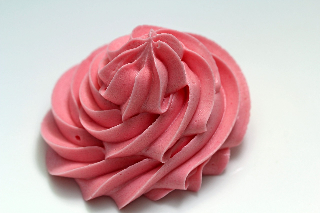 a pink frosted cupcake sitting on top of a white table, inspired by Rose Henriques, art nouveau, foamy waves, red rose, extremely sharply detailed, soap